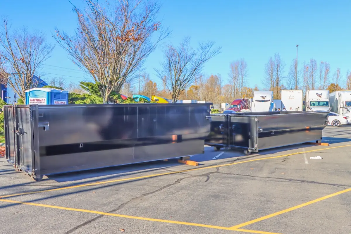 Professional dumpster rental service with roll-off container on residential driveway in Gun Plain